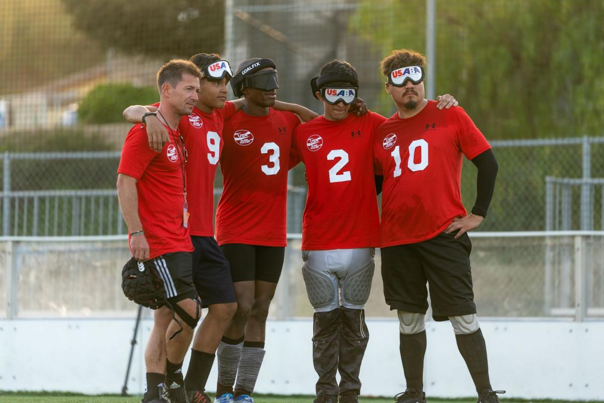 Five male athletes wearing a red T-shirt